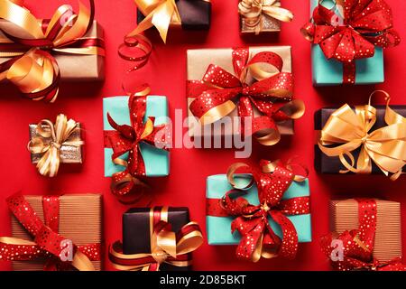 Festively wrapped gift boxes on red background. Flat lay style. Holiday concept Stock Photo