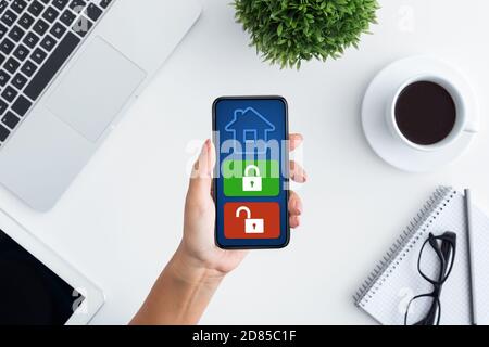 Lady using her cellphone with home security application Stock Photo