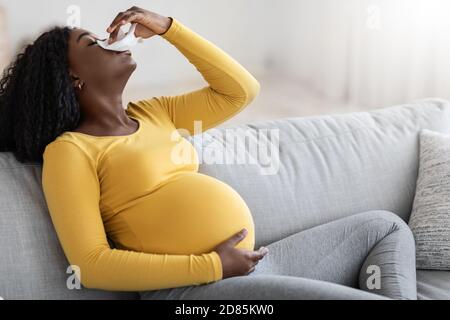 Black pregnant woman with nosebleed or bleeding from her nose Stock Photo