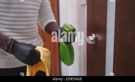 Close up, african american black man wiping and disinfecting door handle. High quality photo Stock Photo