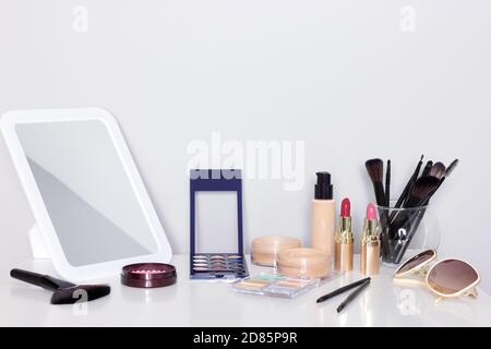 Make-up products with mirror on dressing table. Vanity table with makeup accessories Stock Photo