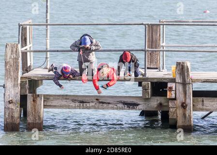 Currabinny, Cork, Ireland. 27th October, 2020. Jane O'Leary from Carrigaline helps her three children, Maymie, Billy and Paddy fish for crab on a cool afternoon on the pier at Currabinny, Co. Cork, Ireland.  - Credit; David Creedon / Alamy Live News Stock Photo