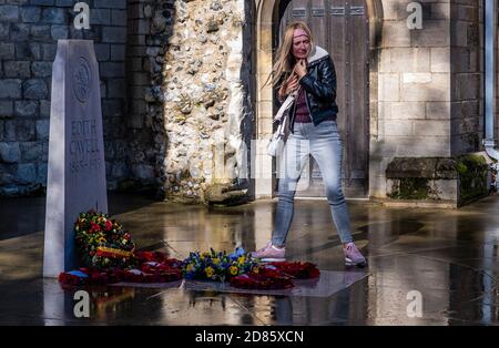 Woman at Edith Cavell's grave, a First World War nurse, Norwich Cathedral, Norwich, Norfolk, UK Stock Photo