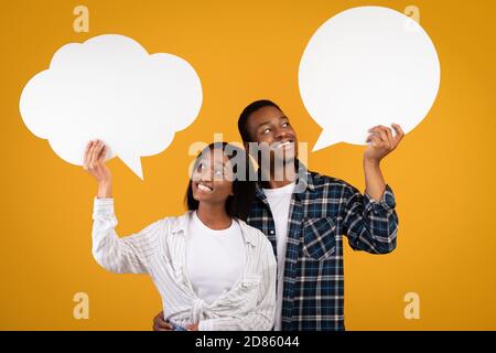 heerful pensive young african american guy and woman in casual look at abstract bubble for thoughts Stock Photo