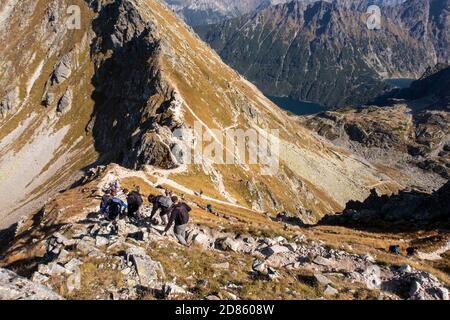 Tatra Mountains, Poland, 21/09/2020. Tourists hiking on a trail on a mountain pass towards Miedziane Peak in Tatra Mountains during autumn. Mountain l