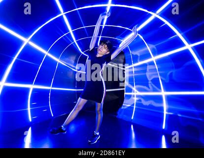 Slim attractive asian girl in blue neon light tunnel Stock Photo