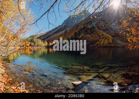 Mountain lake with transparent water and colorful autumnal trees ...