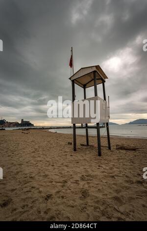 Empty beach in winter with a lifeguard tower and red flag near the small town of Lerici, Gulf of La Spezia, Liguria, Italy, Europe Stock Photo