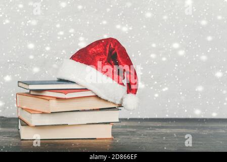 Merry Christmas.books and santa Claus hat on a wooden table.Christmas concept background Stock Photo