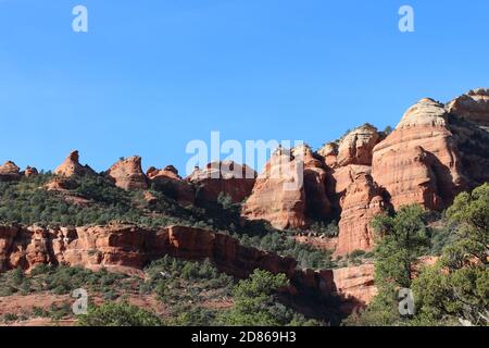 The red sandstone and white limestone mountains of Sedona with evergreen trees growing on the slopes of the eroded mountainside in Arizona, USA Stock Photo