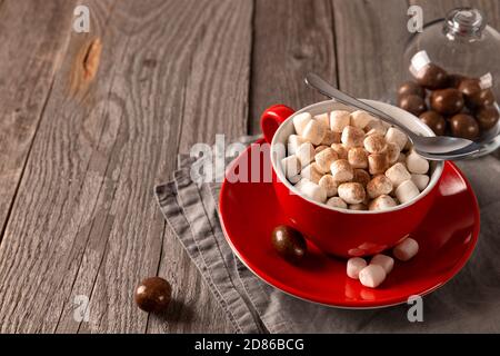 Hot chocolate with marshmallow in red cup on wooden table Stock Photo