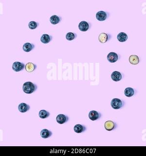 Creative layout made of blueberry on a purple background. Flat lay. Food concept. Macro concept. Stock Photo