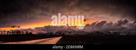 Sagebrush Drive heading toward the Teton Mountains and a colorful sunset produced from the remnants of a thunderstorm and mammatus clouds. Grand Teton Stock Photo