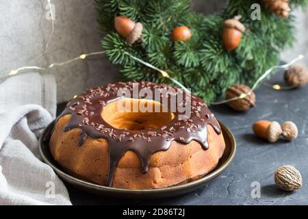 Striped zebra pie, spruce wreath and garland on concrete background. Stock Photo