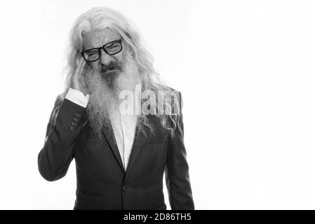 Studio shot of stressed senior bearded businessman wearing eyeglasses while having headache Stock Photo