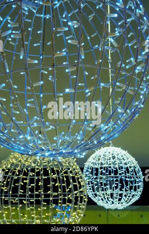 Luminous decorations in mall, sphere from garland hanging in shopping center. Selective focus, Christmas ornaments Stock Photo