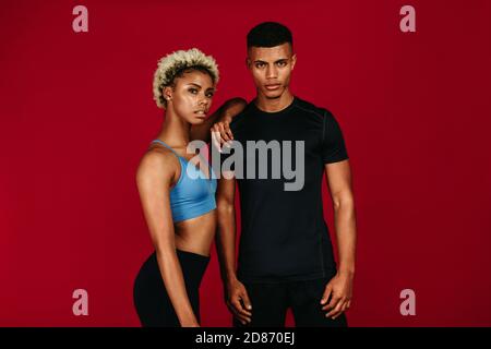 Portrait of african american fitness couple. Fit woman standing with her arm resting on shoulder of muscular man. Stock Photo