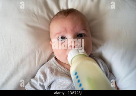 baby drinking milk from bottle Stock Photo