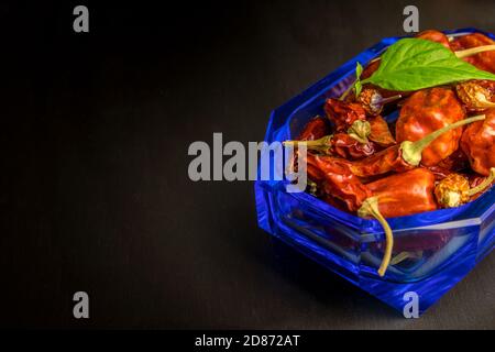 Different types of chili peppers on a black background. Vegetable background, copy space. Hot spices. Stock Photo