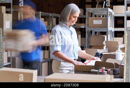 Warehouse workers hurry in blur motion to deliver parcels. Fast delivery concept Stock Photo