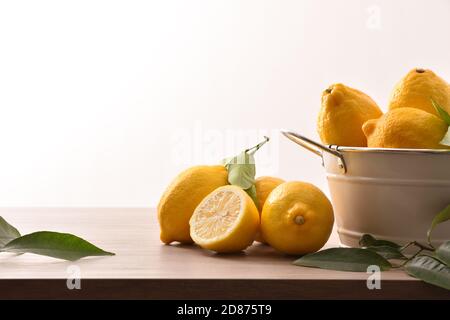 Basket full of lemons on wooden kitchen bench isolated background. Front view. Horizontal composition. Stock Photo