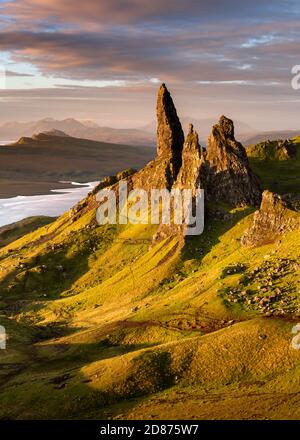 The Old Man of Storr rock pinnacles at sunrise with vibrant Summer sunlight from the morning sun and dramatic clouds overhead. Isle of Skye, Scotland, Stock Photo