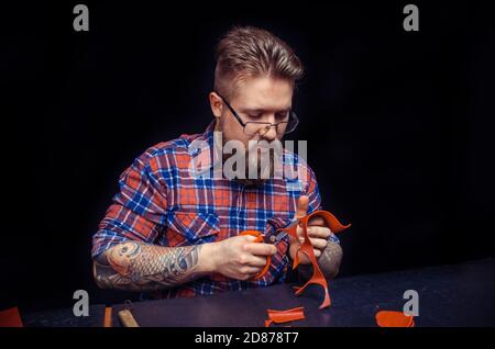 Man working with leather wording with leather goods in studio Stock Photo