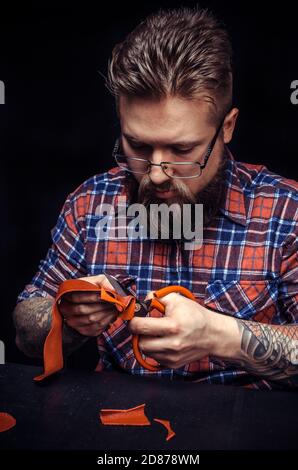 Leather master produce a leatherwork in a workshop Stock Photo