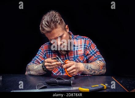 Handicraftsman creating new leatherwork in his tanning shop Stock Photo