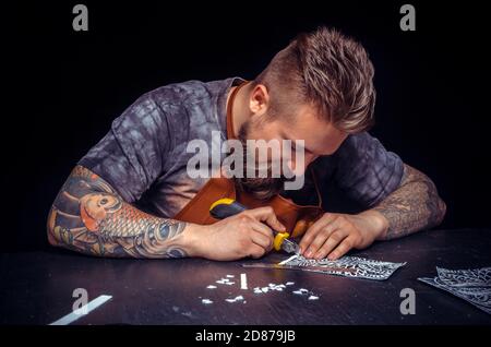 Skinner creates a new leather product in his leather studio Stock Photo