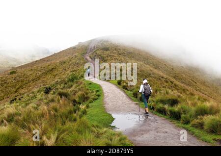 Two women hiking the Pichincha volcano ascent in the mist along the walking trail, Quito, Ecuador. Stock Photo