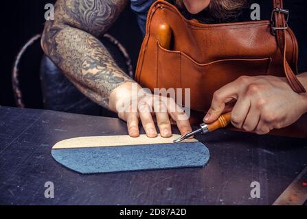 Leather Craftsman forming new leather production in his leather shop Stock Photo