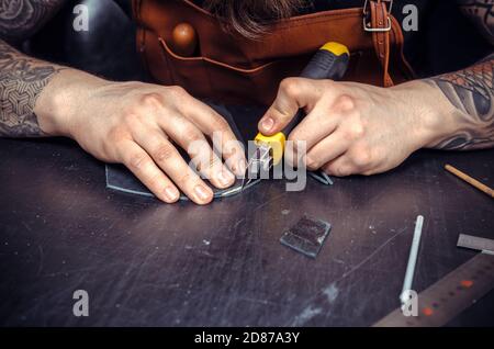 Leather cutter producing leather goods Stock Photo