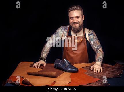 Professional Leather Worker creates quality product of leather at workplace Stock Photo