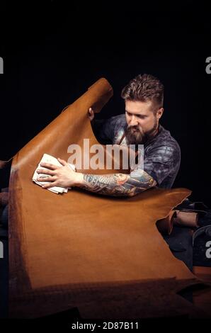 Leather Artist working on a new leather product in leather studio Stock Photo