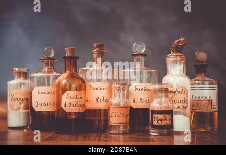 closeup of ancient apothecary pots with ingredients for medicine isolated over dark background