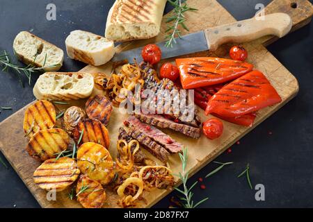 Grilled beef steak with mixed vegetables and crusty Italian bread Stock Photo