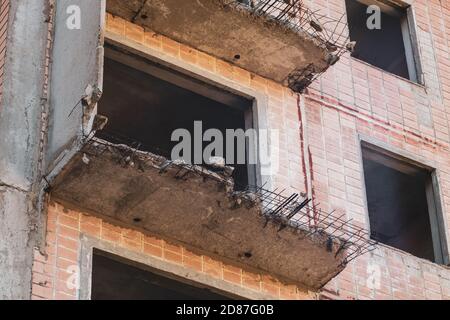 High multistorey abandoned soviet building facade with crashed balconies close-up. Weathered housing estate, unfinished city of nuclear scientists in Stock Photo