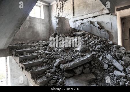 Crashed concrete staircase inside abandoned ruined floor of soviet building. Unfinished city of nuclear scientists in Birky, Ukraine Stock Photo