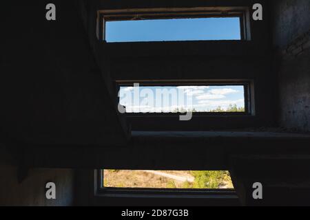 Horizontal window ways composition in dark abandoned staircase. From darkness to colorful sunny view Stock Photo