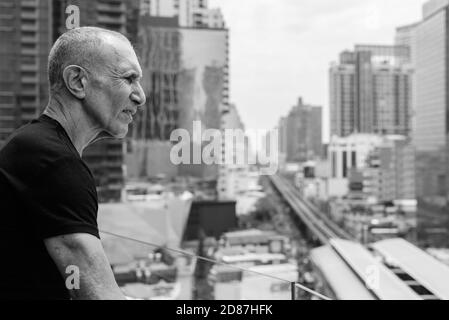 Profile view of bald senior tourist man looking at view of the city in Bangkok Thailand Stock Photo