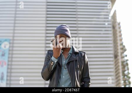 young african man in the city talking on his smartphone Stock Photo