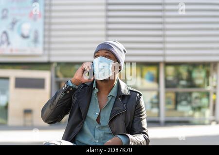 young african man walking through the city wearing the mask Stock Photo