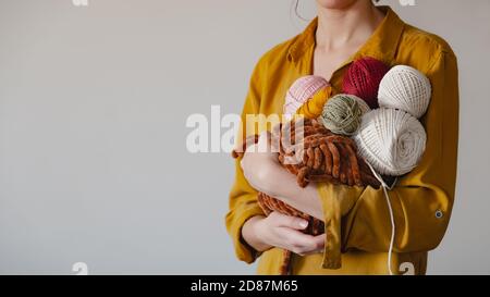 Rolls of cotton ropes in woman hand. Knitting, crocheting, handmade hobby concept with copy space Stock Photo