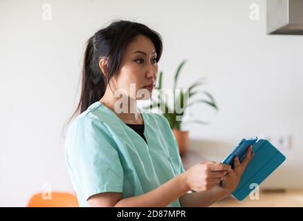 young nurse woman looking  with a tablet in a  doctor's office Stock Photo