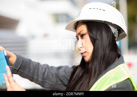 young construction engineer woman with helmet working outside Stock Photo