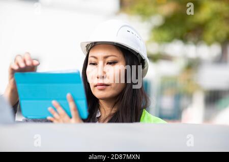 young construction engineer woman with helmet working outside Stock Photo