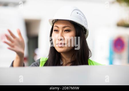 young construction engineer woman with helmet working outside Stock Photo