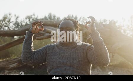 Stressed young african american black man in meditating pose in the park . High quality photo Stock Photo