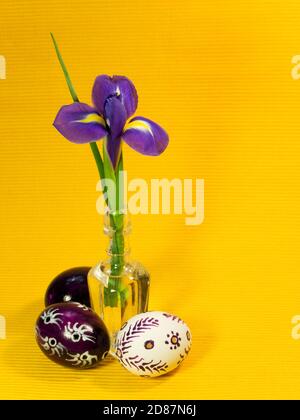 Three painted easter eggs and iris flower Stock Photo